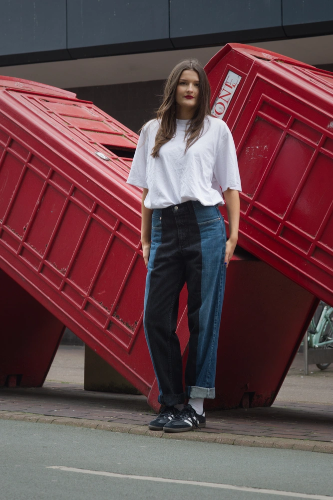 The first model representing the 50s fashion trend. The model is posing in front of a row of slanted telephone boxes.
