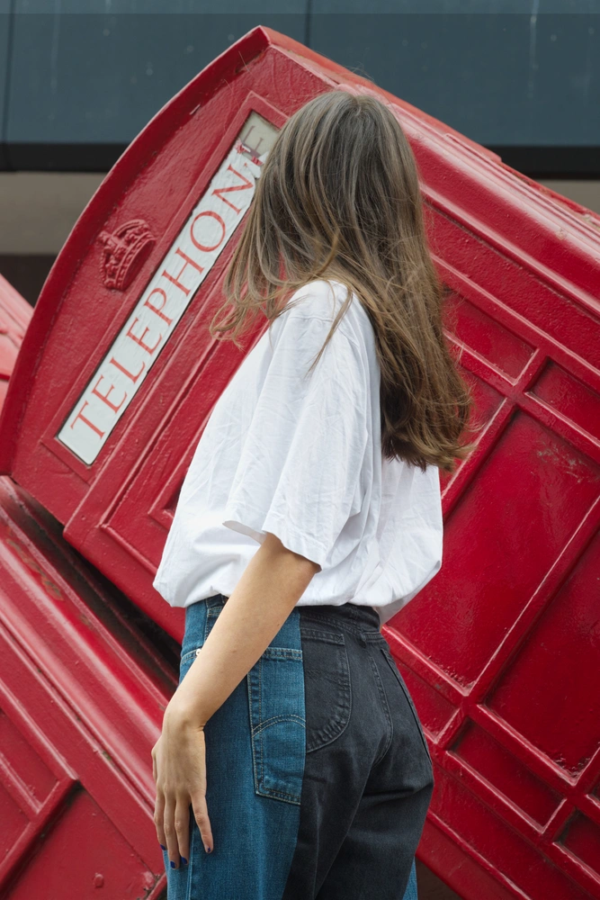 The first model representing the 50s fashion trend. The model is posing in front of a row of slanted telephone boxes, turned away from the camera.
